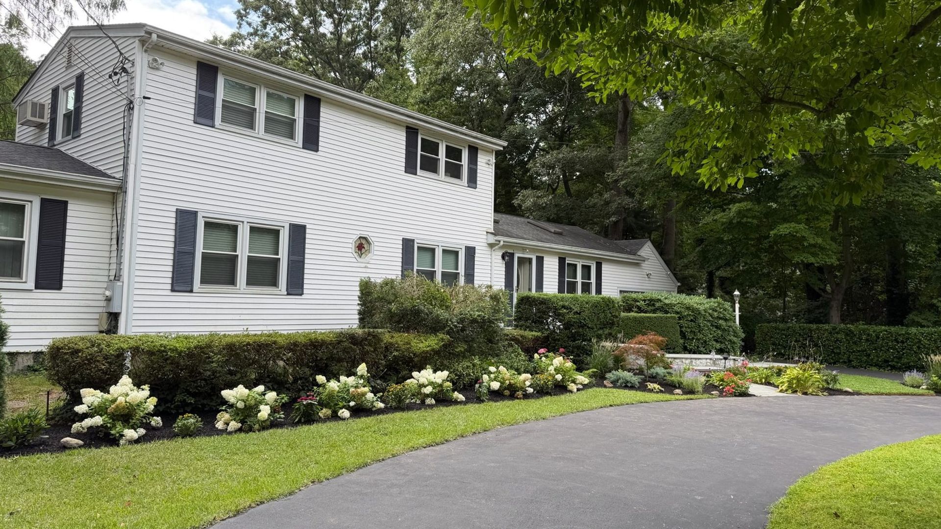 Completed front yard landscape with new plantings on Long Island