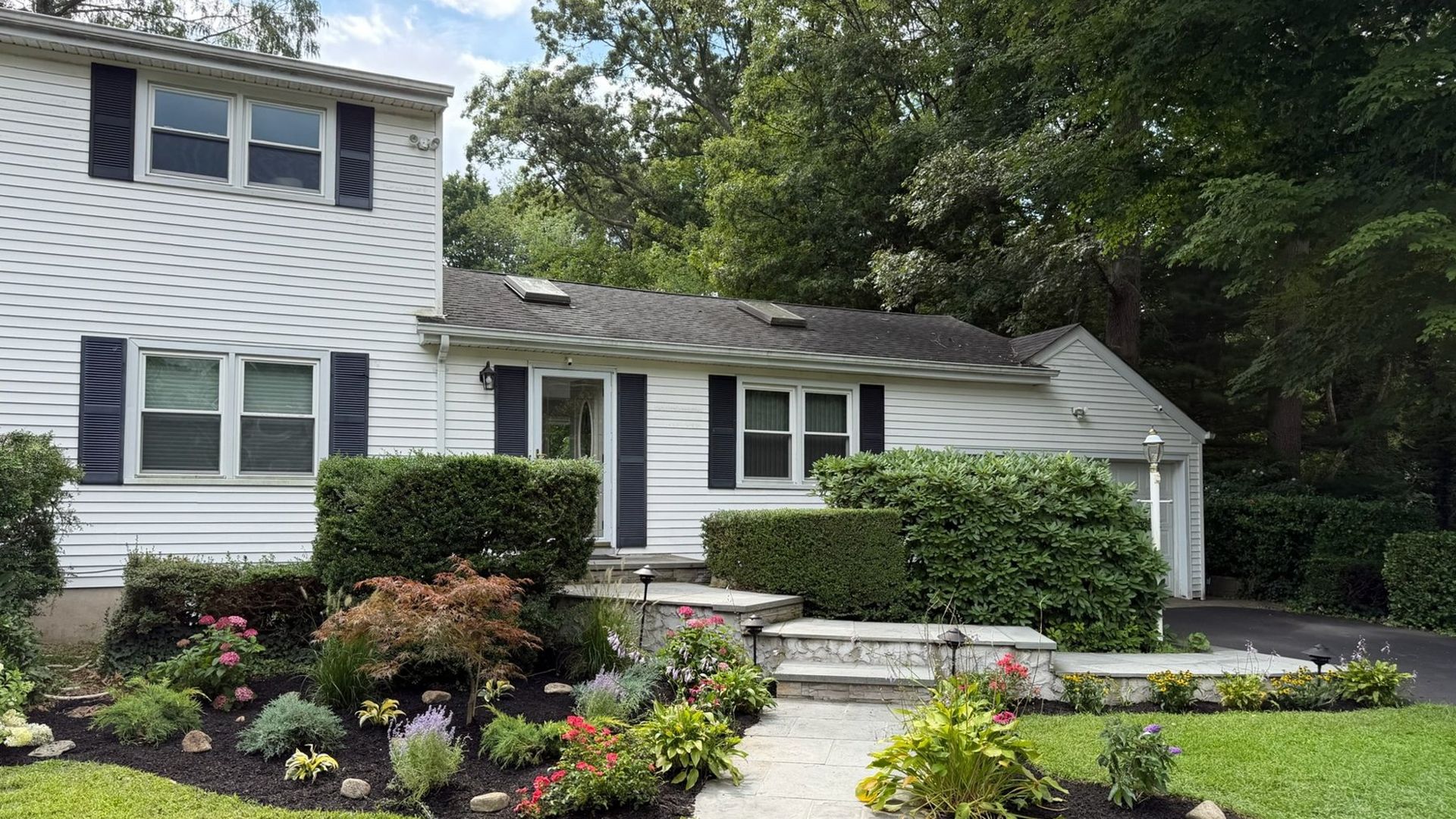 Completed landscape design with new plantings and lawn at a Huntington NY home by Gladiator Landscaping